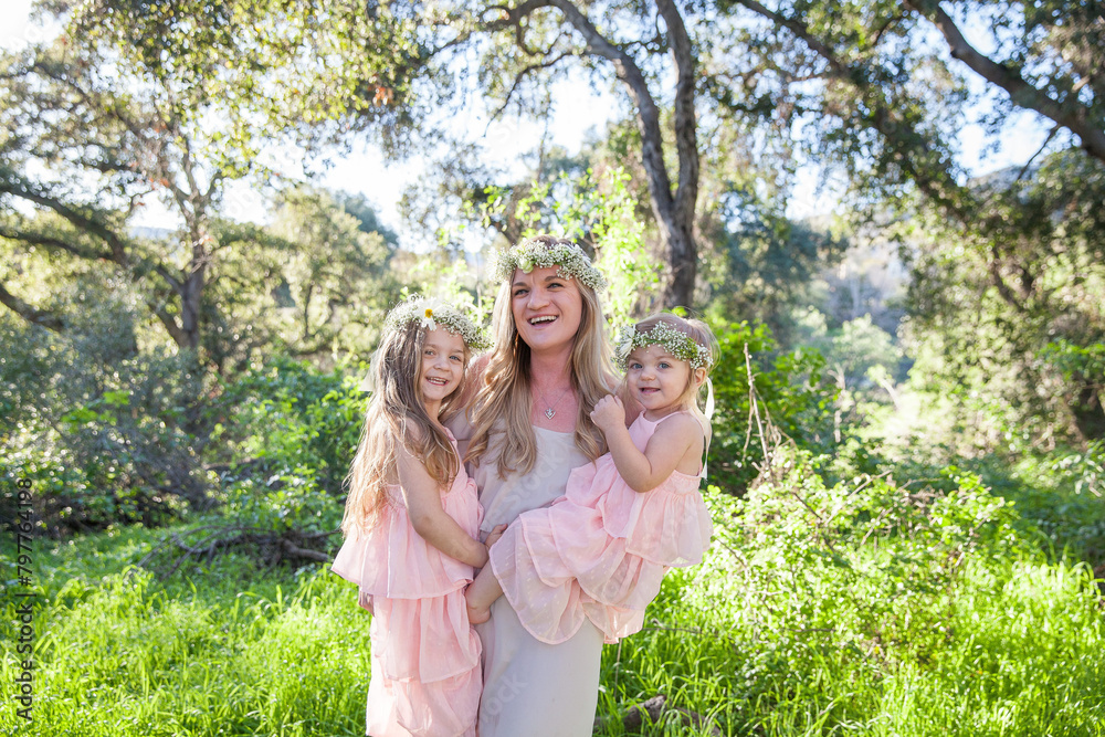 Radiant smiles in nature, a mother's embrace with her girls Radiant smiles in nature, a mother's embrace with her girls