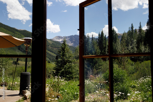 Window view to Colorado's lush landscapes and peaks.