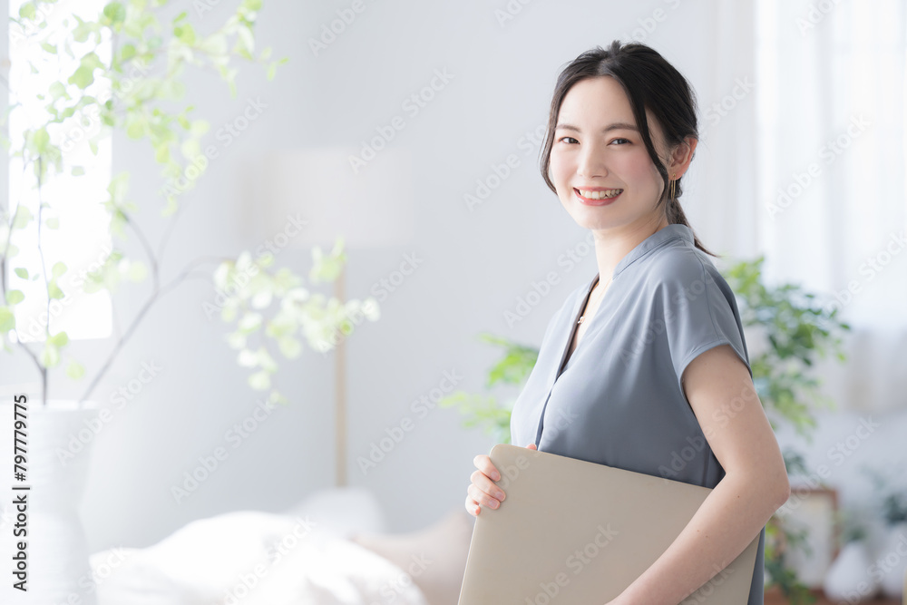 Beautiful woman with laptop in beautiful office window Holding computer and smiling for camera Beautiful woman with laptop in beautiful office window Holding computer and smiling for camera