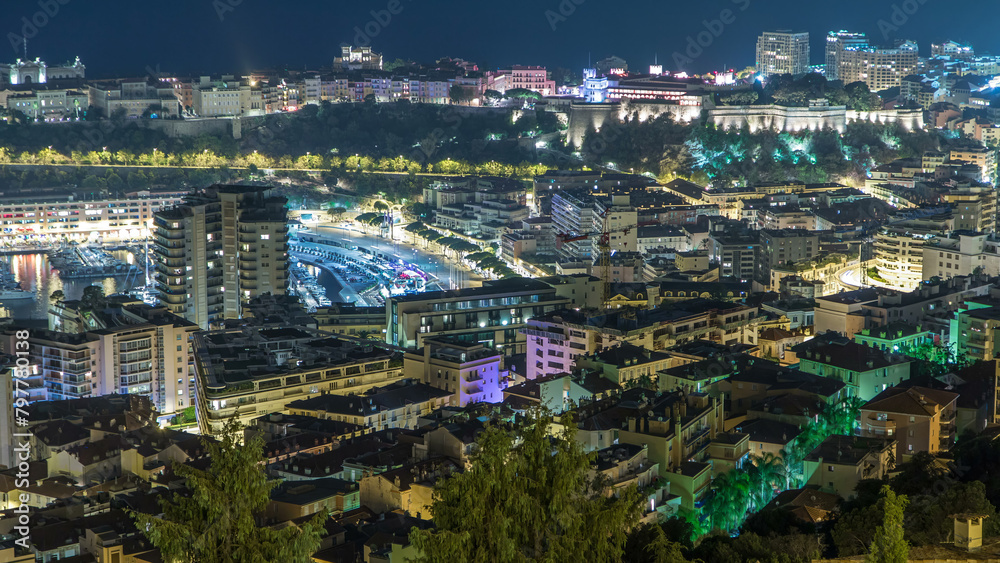 Cityscape of Monte Carlo, Monaco night timelapse with roofs of buildings and traffic on roads.