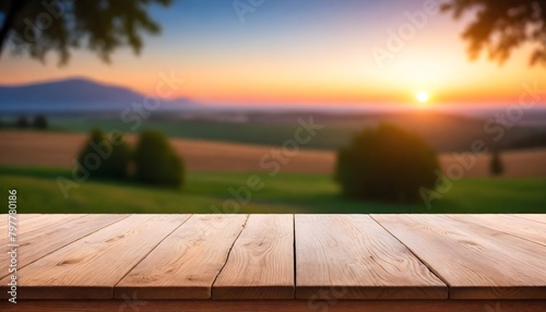 Empty wooden table against a blurred sunset landscape