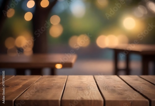 Wooden table in front of blurred nature background with bokeh lights photo