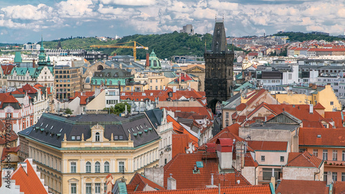 Aerial view of the traditional red roofs of the city of Prague, Czech Republic with the Powder tower and Vitkov Hill in the distance timelapse.