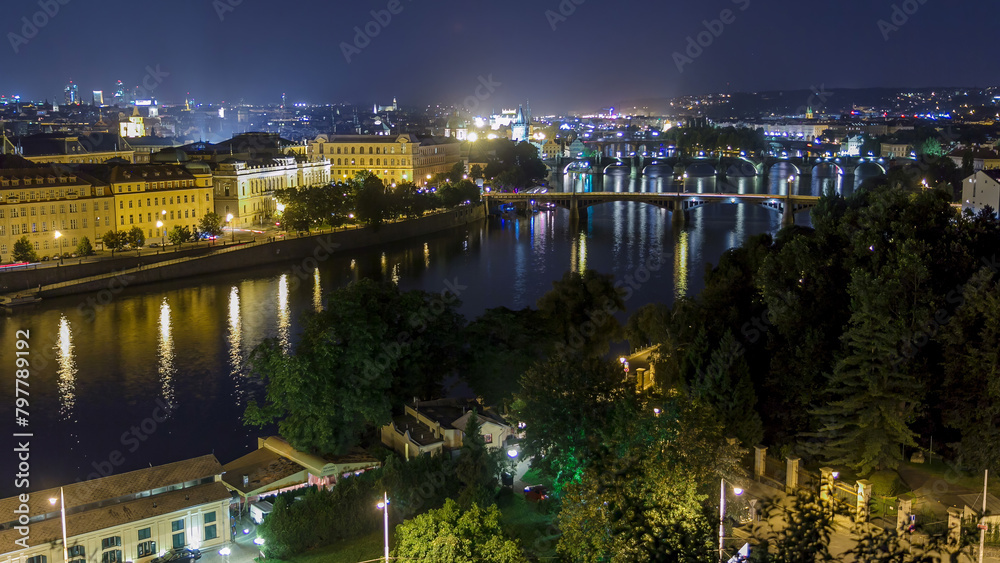 Fototapeta premium Scenic view of bridges on the Vltava river night timelapse and of the historical center of Prague: buildings