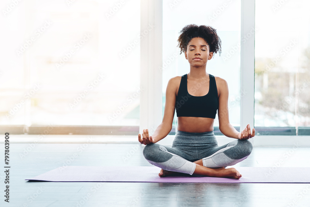 Naklejka premium Home, black woman and yoga with lotus pose for peace, meditation and zen healing indoor with lens flare. Health, fitness and female person with mockup space, spiritual balance and freedom at gym