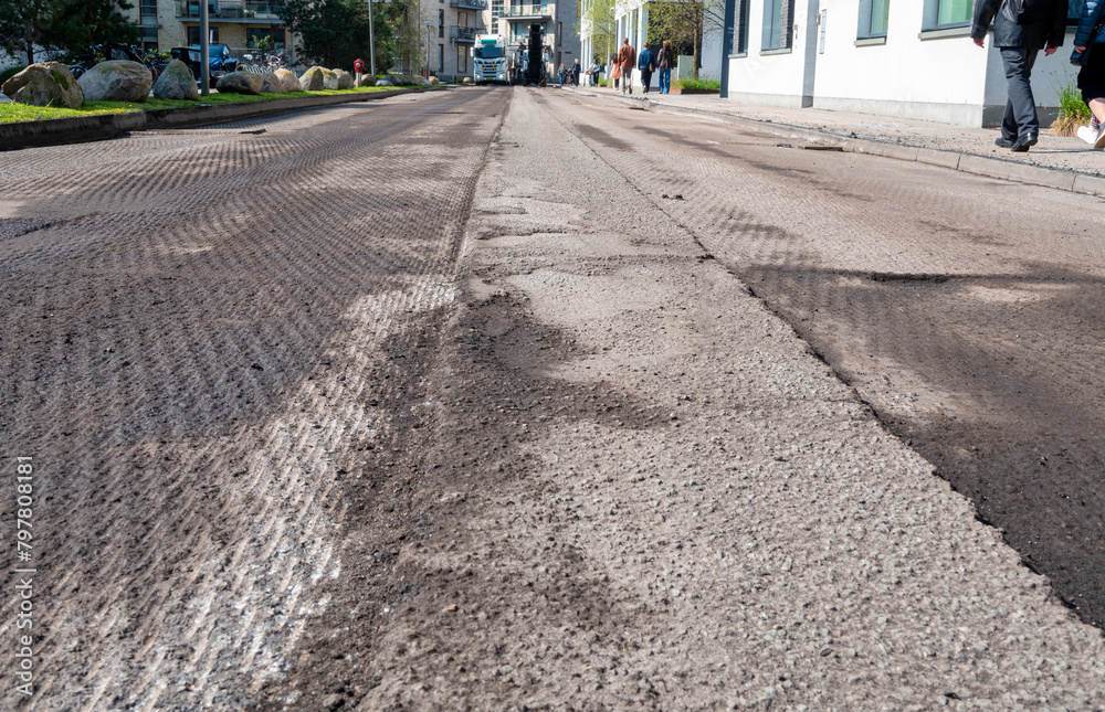 Damaged road prepared by  asphalt milling and grinding scraper machine for road repair. Street renewal with heavy machinery equipment.