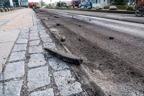 Damaged road prepared by  asphalt milling and grinding scraper machine for road repair. Street renewal with heavy machinery equipment.