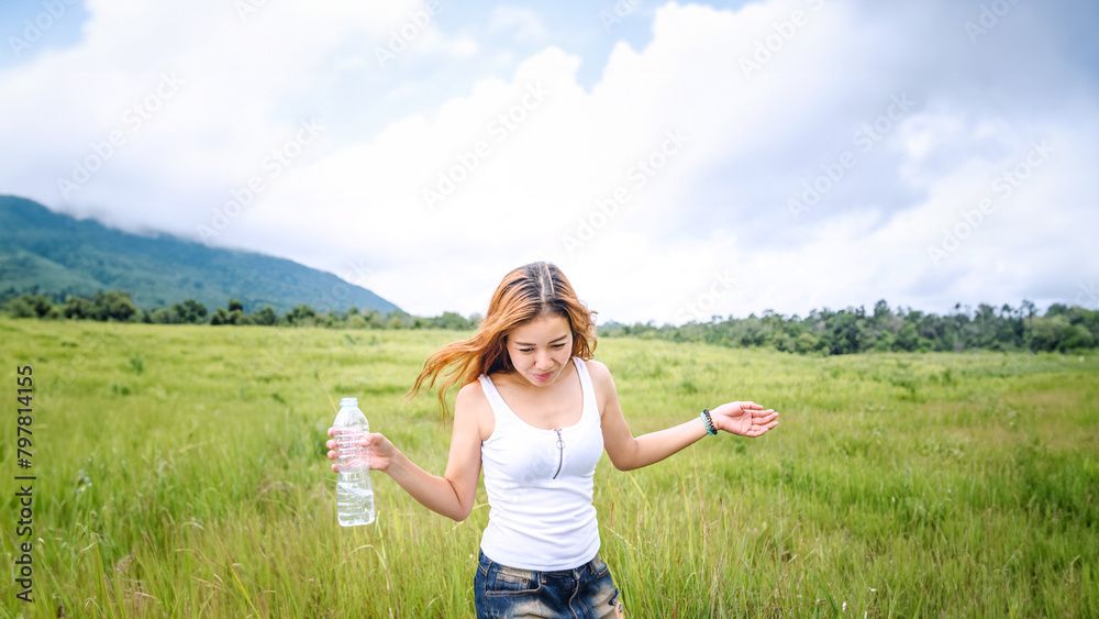 Asian women travel relax in the holiday. Drink Water on a green pasture. Asian women travel relax in the holiday. Drink Water on a green pasture.