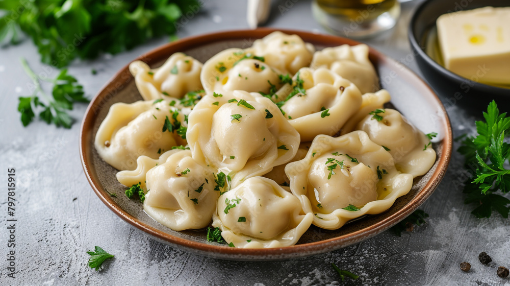 A plate of pelmeni with dumplings filled with minced meat, boiled in water, and topped with butter and parsley. A plate of pelmeni with dumplings filled with minced meat, boiled in water, and topped with butter and parsley.