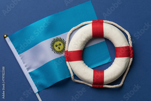 Germany flag and lifebuoy on a colored background, concept on the theme of help from Argentina