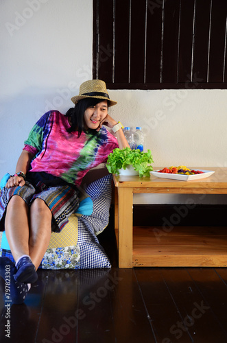 Thai women customer eating breakfast healthy food vegetables fruits mixed salad on ceramic dish with seasoning and topping served in dining room at restaurant of hotel homestay in Chiang Rai, Thailand