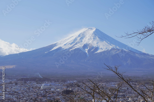 A distant view on Mt Fuji in Japan on a clear,The top parts of the volcano are covered with a layer of snow.