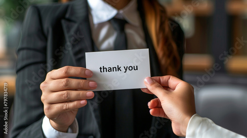Businessman holding a card with a message Thank You. 