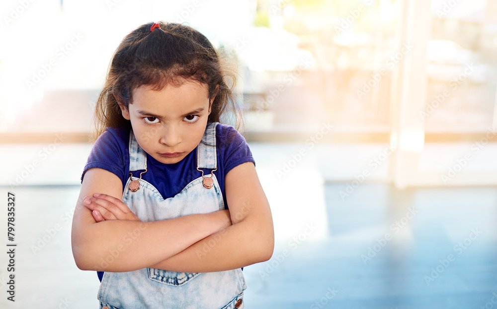 Female child, portrait and angry in house with arms crossed for frustrated, naughty and decision. Girl, upset and facial expression in home with flare for rebel, tantrum and punishment by parents Female child, portrait and angry in house with arms crossed for frustrated, naughty and decision. Girl, upset and facial expression in home with flare for rebel, tantrum and punishment by parents