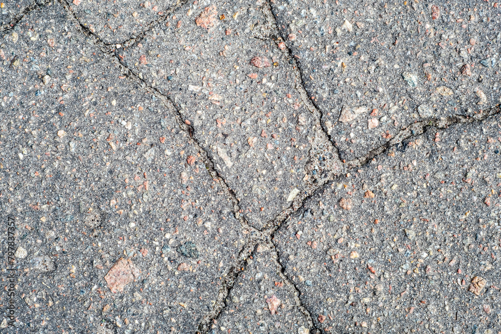Obraz premium Cracked road surface caused by external factors.