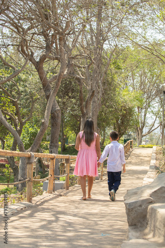 Family members walking together holding hands in a sunny day in a park in Lima Peru