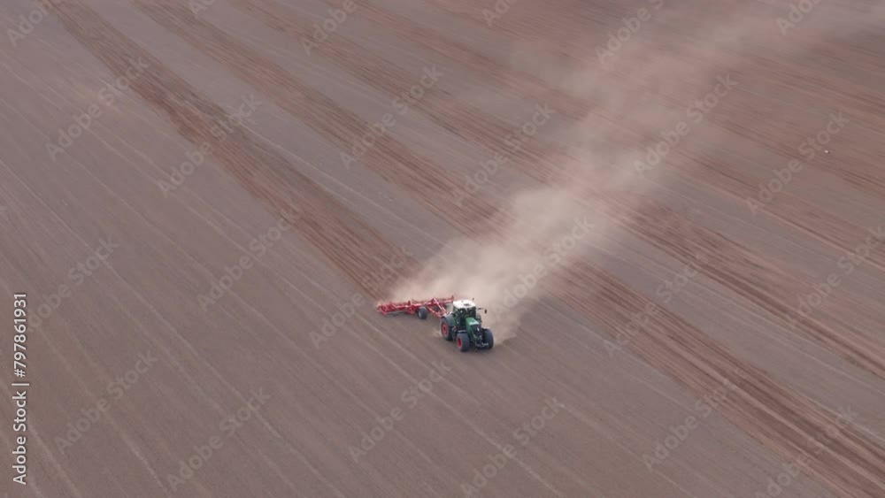 Aerial View of a Farm Tractor Operating a Cultivator in a Field Aerial View of a Farm Tractor Operating a Cultivator in a Field