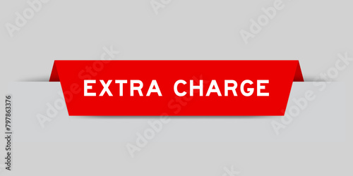 Red color inserted label with word extra charge on gray background