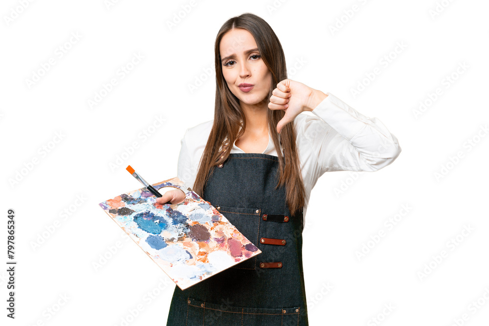 Young artist woman holding a palette over isolated chroma key background showing thumb down with negative expression Young artist woman holding a palette over isolated chroma key background showing thumb down with negative expression