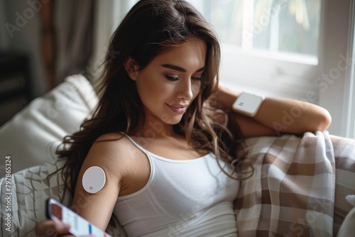 Female with diabetes utilizing continuous glucose monitor. Diabetic female connecting CGM to mobile device to track her glucose levels instantly.