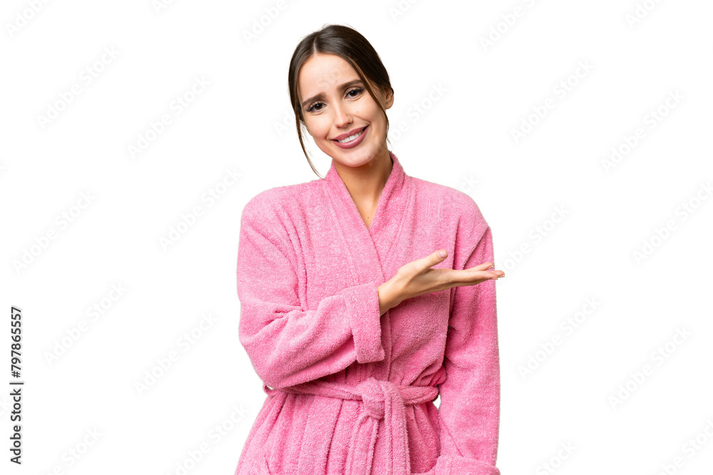 Young beautiful woman in a bathrobe over isolated chroma key background presenting an idea while looking smiling towards Young beautiful woman in a bathrobe over isolated chroma key background presenting an idea while looking smiling towards