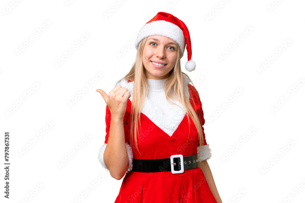 Young blonde woman with christmas hat over isolated chroma key background pointing to the side to present a product Young blonde woman with christmas hat over isolated chroma key background pointing to the side to present a product