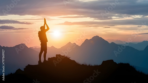 Freedom and adventure of travel, silhouette of a person raising their hands in prayer at the mountain peak with the sun setting in the sky © Blaise
