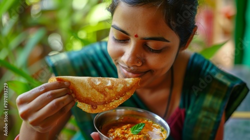 A woman savoring a bite of crispy dosa dipped in tangy coconut chutney, her eyes closed in blissful enjoyment of the flavorful dish.