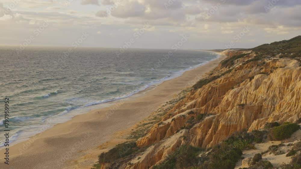 A beautiful beach with a rocky cliff in the background A beautiful beach with a rocky cliff in the background