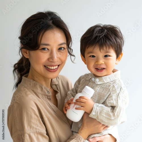 b'Asian mother holding her baby'