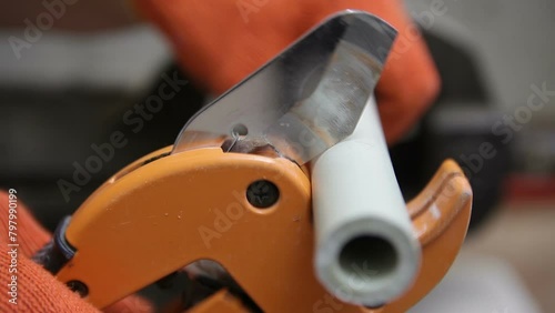 Plumber scissors cuts off the metal-plastic pipe. Pipe cutter for plastic pipes. Side view.