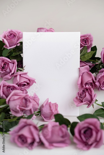 Mockup white poster surrounded by pink roses on a white stand.