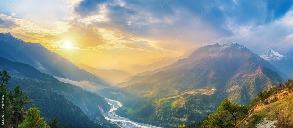 Colorful landscape with high mountains, beautiful winding river, green forest, blue sky with clouds and yellow sunlight at sunset in summer