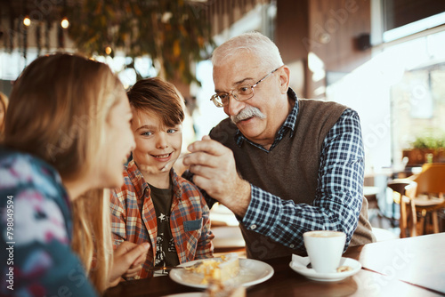 Grandfather enjoying time with grandchildren at a cafe photo
