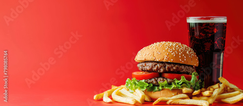 Fried fries and Hamburger, sparkling water drink in glass, colored background with copy space. Banner template for fast food street food. photo