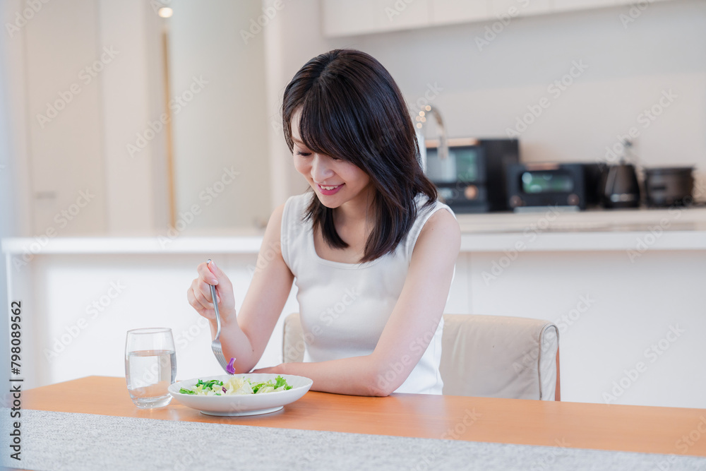 家でご飯を食べる若い女性