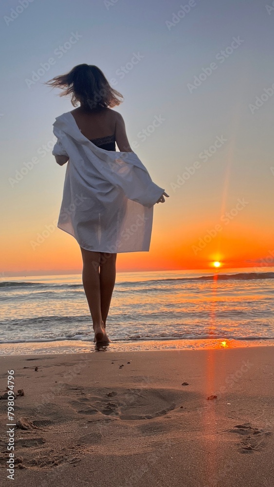 woman meets the sunrise on the seashore woman meets the sunrise on the seashore