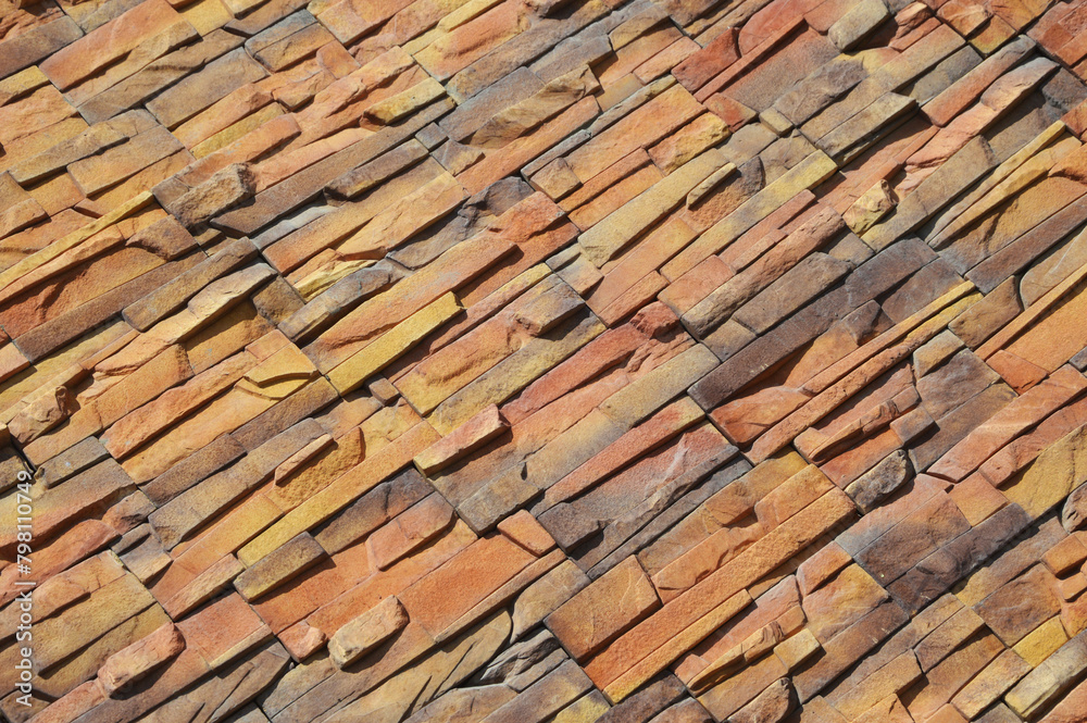 Decorative facing stone imitating a red brick wall. Fragment of the building facade. Decorative facing stone imitating a red brick wall. Fragment of the building facade.