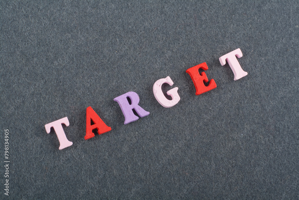 TAREGET word on black board background composed from colorful abc alphabet block wooden letters, copy space for ad text. Learning english concept. TAREGET word on black board background composed from colorful abc alphabet block wooden letters, copy space for ad text. Learning english concept.