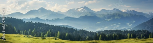 a green field with trees and mountains in the background