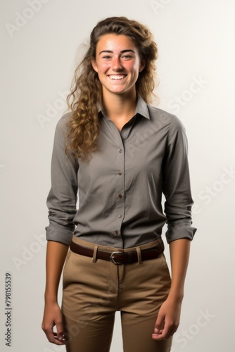b'Portrait of a young woman in a gray blouse and brown pants'