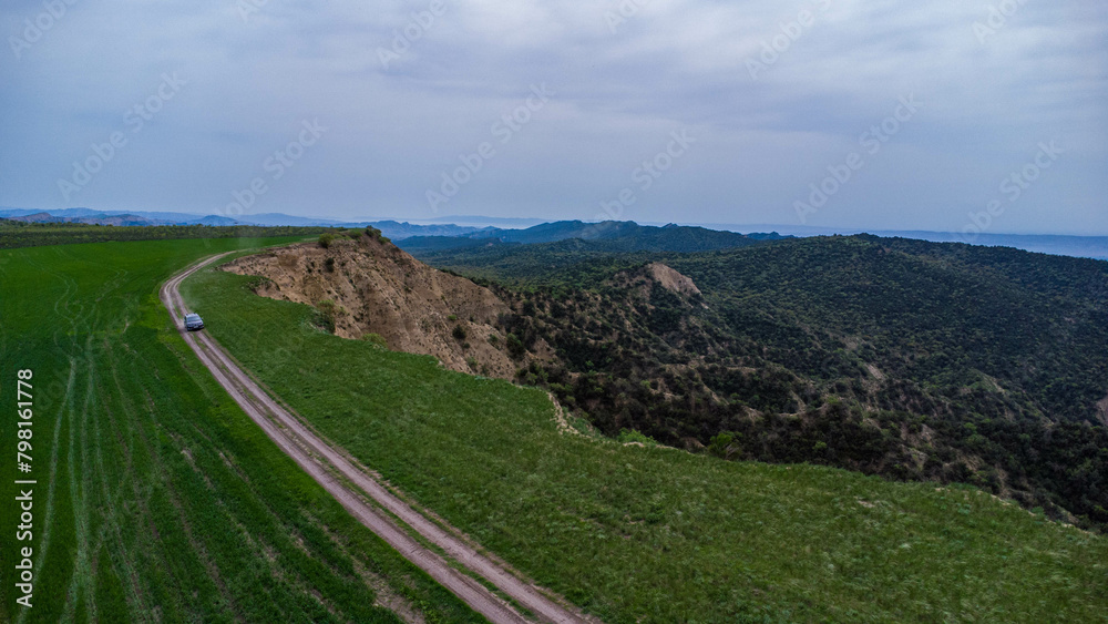 car are move in field near the canyon