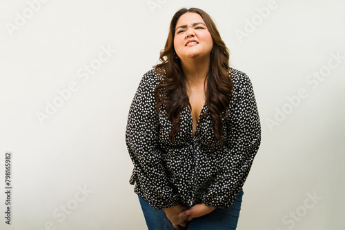 Canvas Print Stressed plus-size woman holding her urge to pee and suffering from incontinence