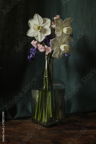 still life with flowers and antique glass bottle, hyacinth and daffodil