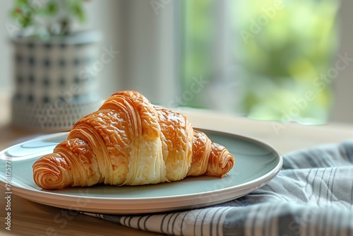 Freshly baked croissant on a ceramic plate by the window. A cozy breakfast setting with natural light  image for food and lifestyle themes. Banner with copy space.