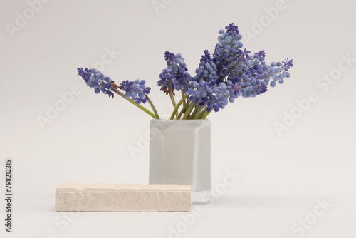 White Stones platform podium, flower in vase on beige light background. Minimal empty display product presentation scene.
