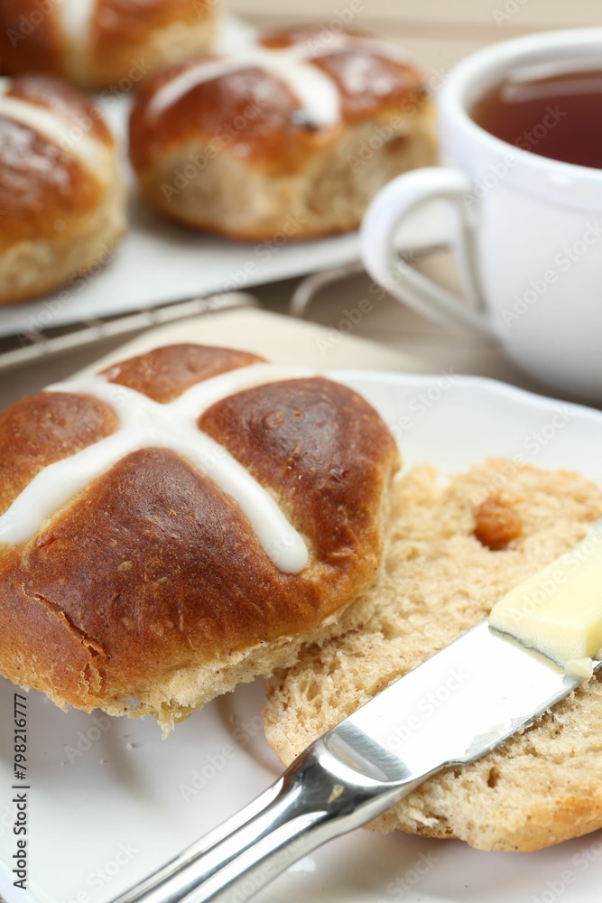 Tasty hot cross bun served on table, closeup Tasty hot cross bun served on table, closeup