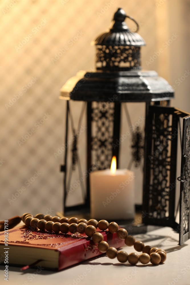 Arabic lantern, Quran and misbaha on white table Arabic lantern, Quran and misbaha on white table