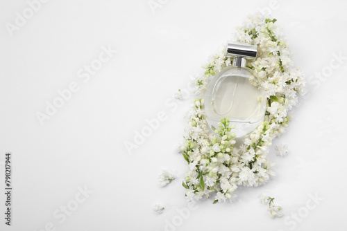 Luxury perfume and floral decor on white background, top view. Space for text