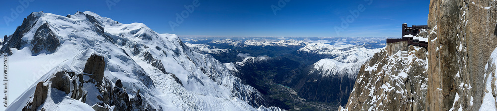 Haute-Savoie, France, 04-25-2024: panoramic view of L’Aiguille du Midi (Needle at midday), the highest spire (3.842 m) of the Aiguilles de Chamonix with the Mont Blanc massif peaks and Chamonix Valley
